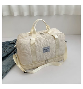 Close-up of cream travel bag showing quilted star texture and separate shoe compartment