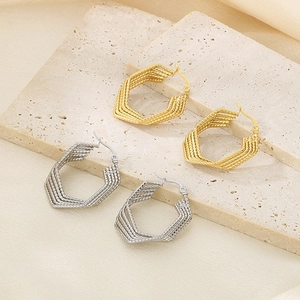 Detailed view of geometric layered hexagonal earrings in gold and silver metal finishes