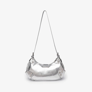 Detail of silver metallic crescent shoulder bag featuring stylish rivets and retro chic vibe