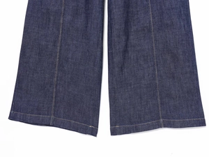 Dettaglio dei pantaloni in denim a gamba larga con cuciture gialle a contrasto e tessuto indaco