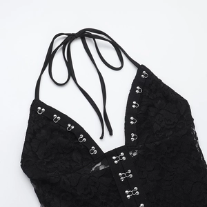 Detail of black floral lace halter top with silver metal buckle and deep V neckline
