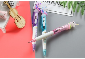 Close-up of three glowing unicorn pens in purple, blue and pink with rainbow patterns