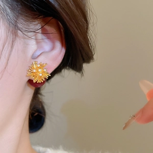 Detailed close-up of 18k gold plated firework stud earrings with zircon crystals on ear
