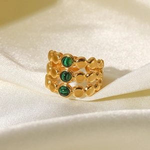 Détail d'une bague multi-rangs plaquée or 18K avec malachite sur tissu en soie