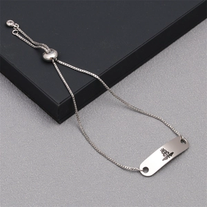 Detail of adjustable skull charm bracelet with engraved silver plaque and cord closure