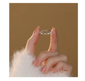 Detailed view of S925 sterling silver hollow heart ring with zircon on warm background