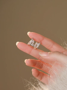 Detailed view of silver C-shaped star hoop earrings with sparkling zircon inlay