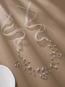 Detail of handcrafted bridal headband with marquise rhinestones and white silk ribbon
