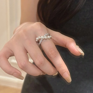 Close-up of double-layer crisscross ring with zircons and gradient white pearls on hand