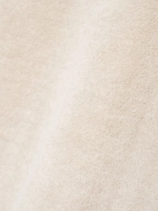 Dettaglio macro della pelliccia sintetica beige chiaro con fibre di peluche di qualità