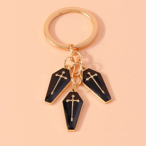 Gothic Schlüsselanhänger mit schwarzen Särgen und goldenen Kreuzen auf rosa Grund