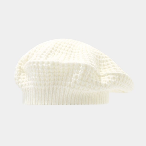 Detailed macro view of the cream knitted beret showing the textured waffle weave pattern
