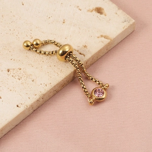 Detail of adjustable gold-plated box chain ring with a pink round zircon on silk