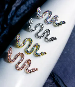 Detailed close-up of 3D snake-shaped nail art charms with sparkling crystals