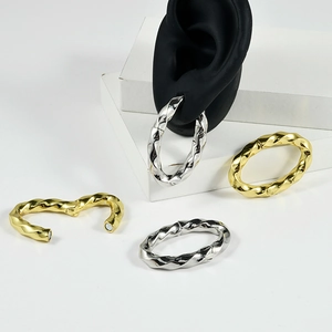 Twisted texture oval magnetic earrings in gold and silver finish on display stands