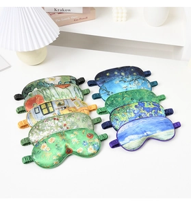 Collection of silk sleep masks featuring Van Gogh oil painting prints on a white desk