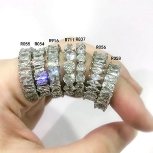 Detailed view of silver eternity bands with emerald, round, and pear cut crystals