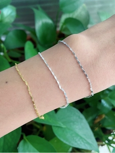 Minimalist square block bracelets in gold and silver finishes shown on a wrist