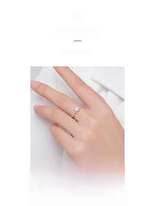 Macro shot of silver ring with pink heart gem and sparkling stones on finger