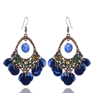 Dettaglio di orecchini boho in bronzo con perline blu scuro e paillettes a frangia