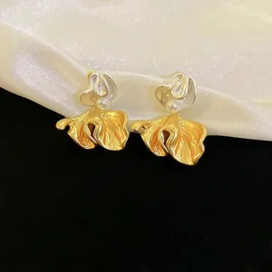 Elegant floral pearl stud earrings with matte gold petals and silver streamline design