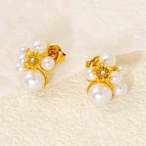 Detail of elegant gold flower earring with pearls and a small central zircon crystal