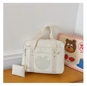 Detailed view of a white canvas JK uniform bag with a heart-shaped transparent window