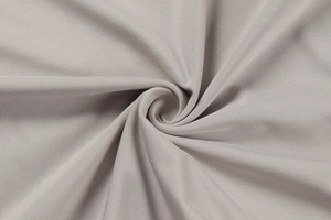 Detailed close-up of light gray knit fabric with spiral pleats and diagonal texture