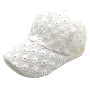 Detailed close-up of white lace baseball cap with floral embroidery and sequins