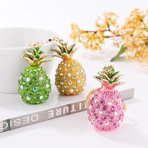 Detailed view of rhinestone-encrusted pineapple keychains in green, yellow, and pink colors