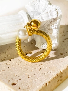 Detail of twisted rope 18K gold ring with a large white pearl and a polished gold sphere