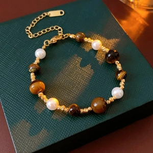 Detailed view of vintage beaded bracelet with pearls, tiger eye stones, and gold beads