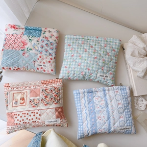 Vue détaillée de quatre pochettes matelassées en coton aux motifs floraux et étiquettes