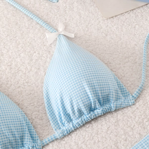 Detail of light blue gingham bikini top with white bow and soft knit texture