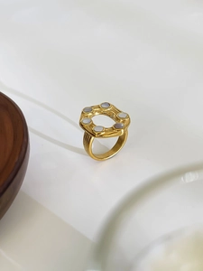 Detail of 18K gold irregular titanium ring with six inlaid round white shell gemstones