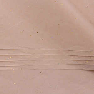 Close-up of brown floral tissue paper with golden holographic glitter for gift wrapping