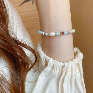 Detail of beaded bracelet featuring baroque pearl and irregular beads on wrist