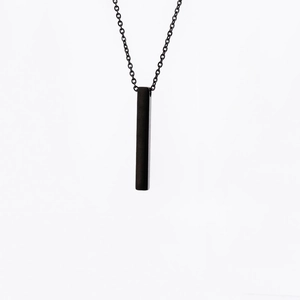 Detailed view of a sleek black rectangular bar pendant on a fine metal chain necklace