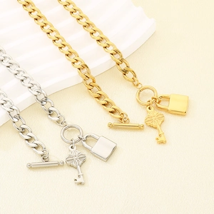 Colliers gourmettes en or et argent avec pendentifs clé et cadenas vintage exposés