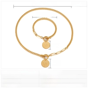 Detail of gold stainless steel coin jewelry set with toggle clasp and Queen pendant