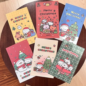 Top-down view of six colorful Christmas cartoon gift bags on a wooden surface