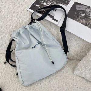 Detailansicht hellblauer wasserdichter Nylon-Rucksack mit Kordelzug auf einem Plüschteppich