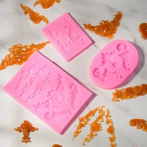Roze siliconen mallen set met barok reliëf voor fondant en hars op marmeren achtergrond