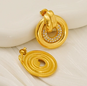 Detailed view of gold plated round stud earrings with shimmering white cubic zirconia stones