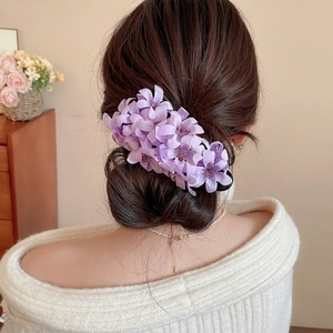 Elegant purple floral hair clip for women styled on a brunette bun for a sweet aesthetic