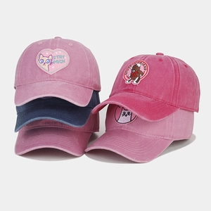 Detailed macro view of embroidered cat and bear patches on washed cotton baseball caps