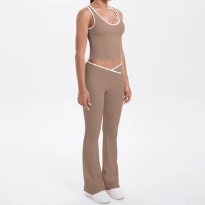 Détail du pantalon de yoga évasé à taille croisée et débardeur de sport bicolore
