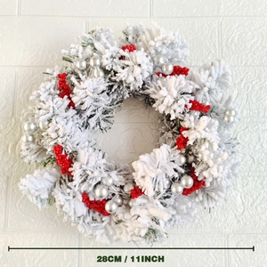 Close-up of 28cm Christmas wreath with red berries, silver baubles, and artificial snow