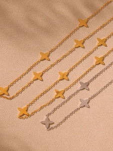 Detailed view of layered four-leaf clover necklaces in 18k gold and silver plated steel