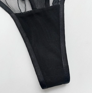 Detail shot of sheer black mesh thong showing intricate embroidery and seam craftsmanship
